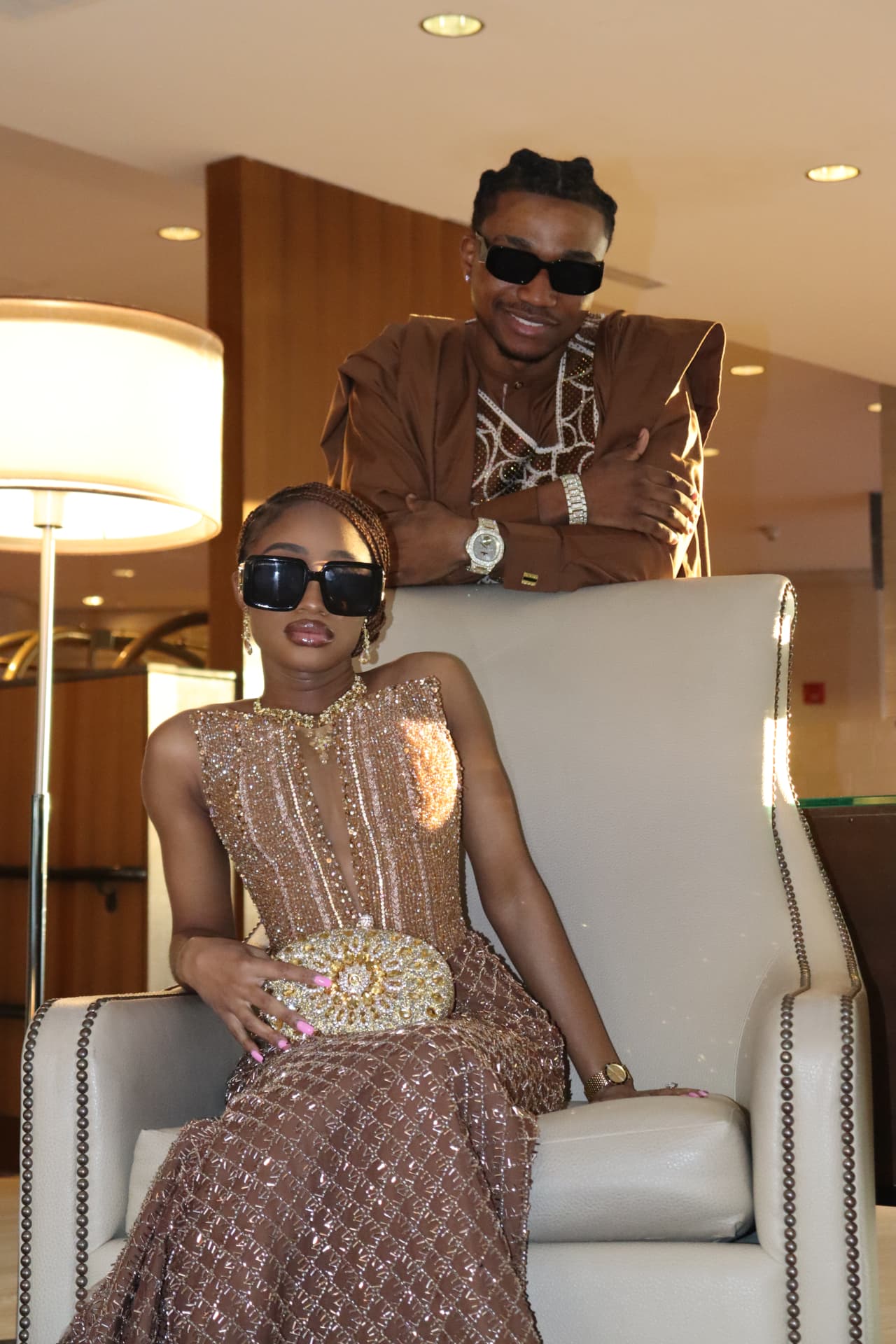 Couple portrait with sunglasses in a warm hotel lounge